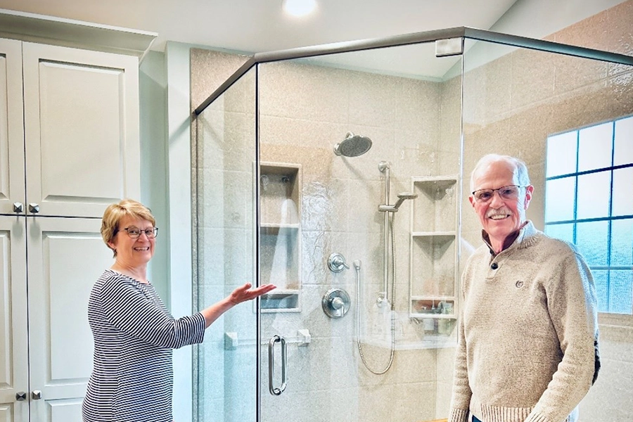 This is a photo of Mr. and Mrs. Sunder of Springfield, IL. They are loyal clients who just had a bathroom remodel completed by local contractor Sutton's Inc. of Springfield, IL. They are pictured next to their new shower in their newly remodeled bathroom.