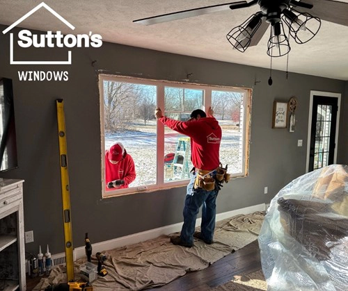 This is a photo of Sutton’s Inc. employees installing a window in a living room at a house in Springfield, IL during the winter.